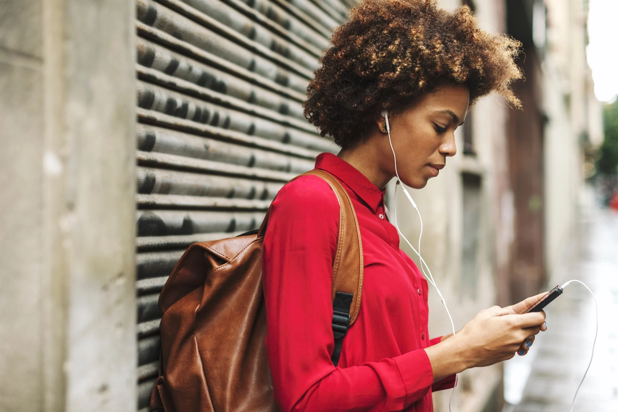 Young woman with bck pack hearing music with earphones