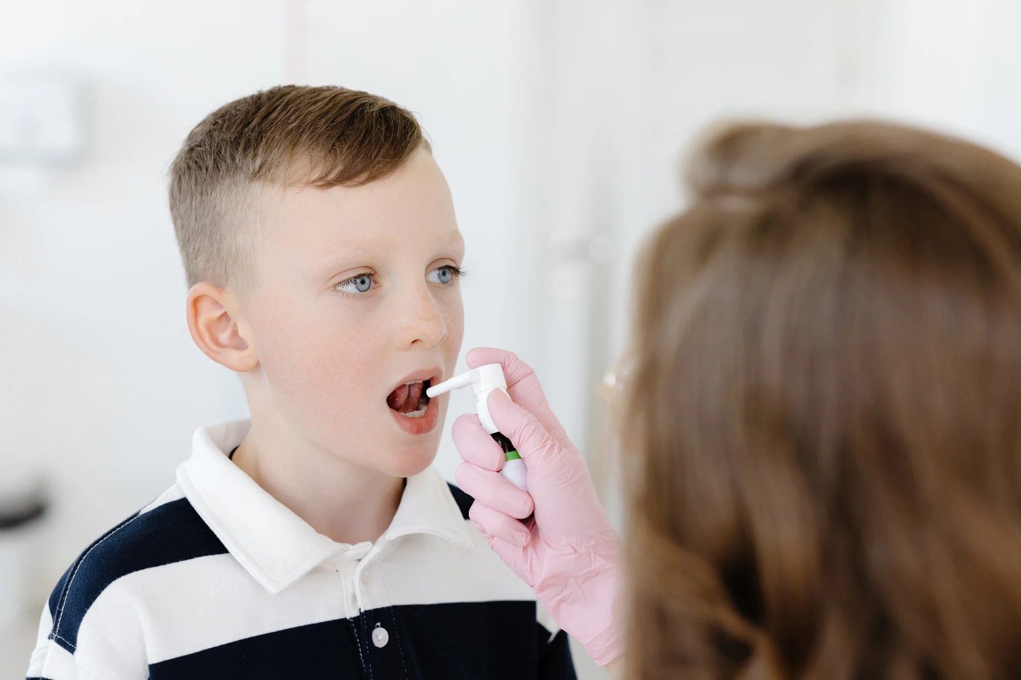 An allergist uses a spray for a patient to treat allergies. Allergen-specific immunotherapy